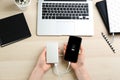 Woman charging mobile phone with power bank at table, top view Royalty Free Stock Photo