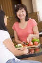 Woman Chatting To Friend While Preparing Meal