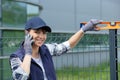 Woman check level metal fence and using phone Royalty Free Stock Photo