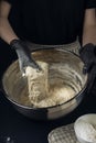 Woman in checkered apron and black gloves mixing yeast dough with hands. Process of making bakery. Adjarian Khachapuri Recipe Ã¢â¬â