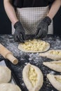 Woman in checkered apron and black gloves spread the cheese filling on the dough. Process of making bakery. Adjarian Khachapuri Royalty Free Stock Photo