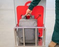 Woman checking backpack metal cage checking carry-on luggage at airport. Royalty Free Stock Photo