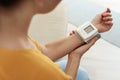 Woman checking blood pressure with sphygmomanometer at home, closeup. Royalty Free Stock Photo