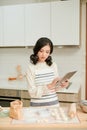 Woman checking a cookies recipe on a tablet in her kitchen for making cookies at home Royalty Free Stock Photo