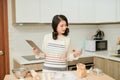 Woman checking a cookies recipe on a tablet in her kitchen for making cookies at home Royalty Free Stock Photo