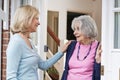 Woman Checking On Elderly Female Neighbor