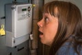 Woman is checking electricity meter - expensive electricity conc