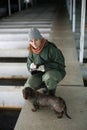 Woman checking fish reservoirs, writing in notebook