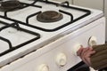 Woman checking gas, trying to turn on gas on old gas stove Royalty Free Stock Photo