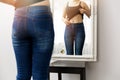 Woman checking her body in front of mirror Royalty Free Stock Photo