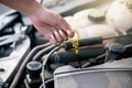 Woman checking her car oil. Woman repairing her car engine. Mechanic looking for a vehicle problem. Closeup of hand of Royalty Free Stock Photo