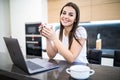 Young woman checking her emails in the morning on a laptop