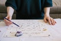 Woman checking natal chart. Beautiful hand drawn astrology background.