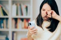 Woman Checking Smartphone Rubbing her Dry Eyes Royalty Free Stock Photo