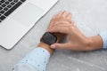 Woman checking stylish smart watch at grey marble table, closeup Royalty Free Stock Photo