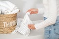 Woman checking tag on beach towel for laundry indoors