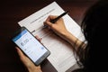 A woman checks her account balance on phone. Lack of money, filling out unemployment benefits form.  All screen graphics are made Royalty Free Stock Photo