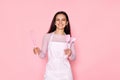 Woman in chef apron in whose pocket a whisk and a spatula