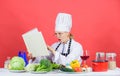 Woman chef cooking healthy food. Girl read book best culinary recipes. Culinary education concept. Female in hat and