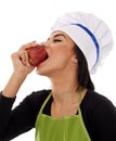 Woman chef eating red apple Royalty Free Stock Photo