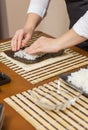 Woman chef filling japanese sushi rolls with rice Royalty Free Stock Photo