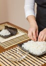 Woman chef filling japanese sushi rolls with rice Royalty Free Stock Photo