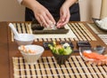 Woman chef filling japanese sushi rolls with rice Royalty Free Stock Photo