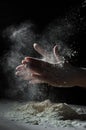 Chef hand clap with splash of white flour and black background with copy space. Royalty Free Stock Photo