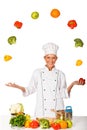 Woman chef juggling with fresh vegetables. Isolated Royalty Free Stock Photo