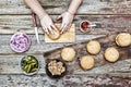 The woman-chef prepares burgers. Burger burgers and burger ingredients on a wooden kitchen table Royalty Free Stock Photo