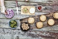 The woman-chef prepares burgers. Burger burgers and burger ingredients on a wooden kitchen table Royalty Free Stock Photo