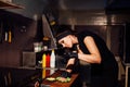 Beautiful woman chef prepares a hamburger in the kitchen of the restaurant Royalty Free Stock Photo