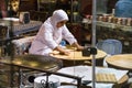 Woman chef rolls the dough with a rolling pin