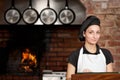 Woman Chef standing in the kitchen with wood oven Royalty Free Stock Photo