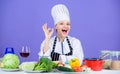 Woman chef wear hat apron near table ingredients. Girl adorable chef teach culinary. Best culinary recipes to try at Royalty Free Stock Photo