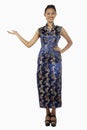 Woman in cheongsam smiling with welcoming hand gesture. Conceptual image