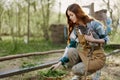 A woman with a chicken in her hand checks the freshness of organic feed in the bird feeder at an organic farm