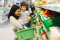 Woman and child boy during family shopping with trolley at supermarket Royalty Free Stock Photo