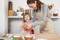 Woman and child cooking with egg laughing