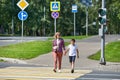 Woman and child cross road at crosswalk