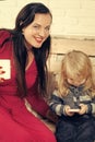 Woman and child drink milk . Small boy and girl on bench with cell phone Royalty Free Stock Photo