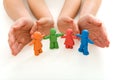 Woman and child hands protecting plasticine people