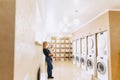 woman with a child on her hands in the laundry is waiting for cl Royalty Free Stock Photo