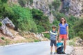 Woman with a child hitchhiking, The girl catches the car Royalty Free Stock Photo