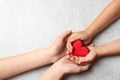 Woman and child holding heart on grey stone background, space for text. Donation concept Royalty Free Stock Photo