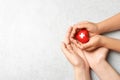 Woman and child holding heart on grey stone, top view with space for text. Donation concept Royalty Free Stock Photo