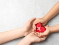 Woman and child holding heart on grey stone background, top view. Donation concept Royalty Free Stock Photo