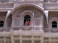 A woman and a child on one of the decorated balconies of the Mehrangarh Fort in the blue city of Jodhpur, India