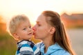 Woman and child outdoors at sunset. Mother kissing her son. Royalty Free Stock Photo