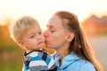 Woman and child outdoors at sunset. Mother kissing her son. Royalty Free Stock Photo